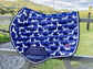 The Snag jump saddle pad draped on a rail with paddock behind