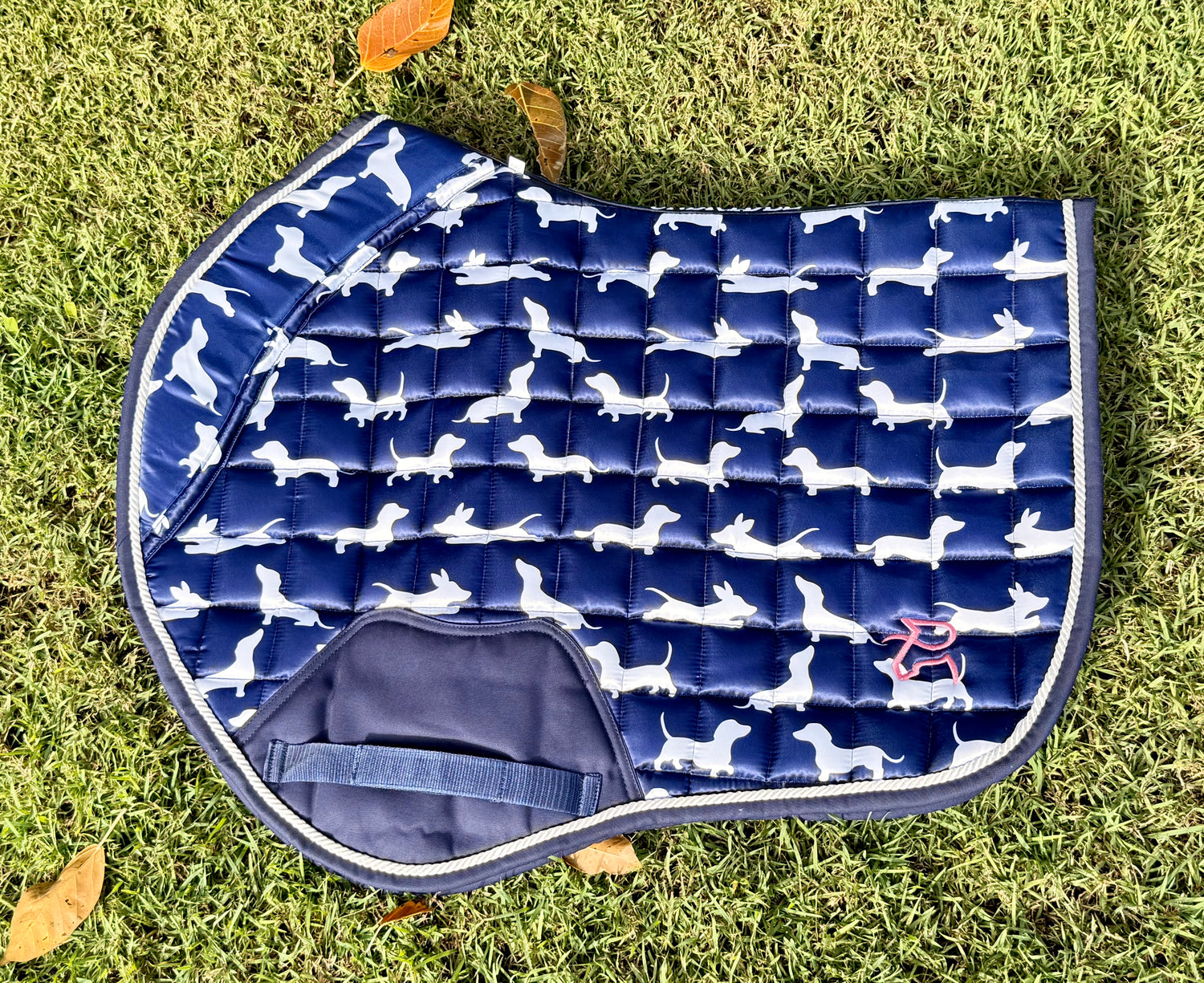 The Snag navy dachshund-print jump saddle pad, flat lay