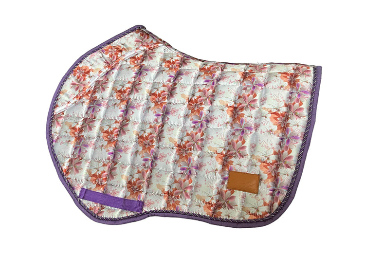 Spring Bloom floral jump saddle pad with purple trim on grass